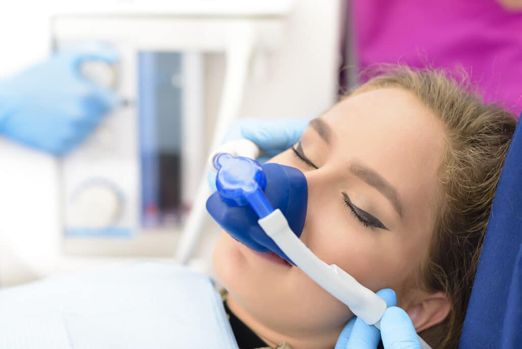 A woman sleeping peacefully while receiving dental treatment with mild sedation